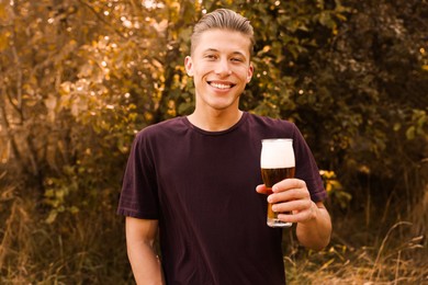 Photo of Young man with glass of beer outdoors