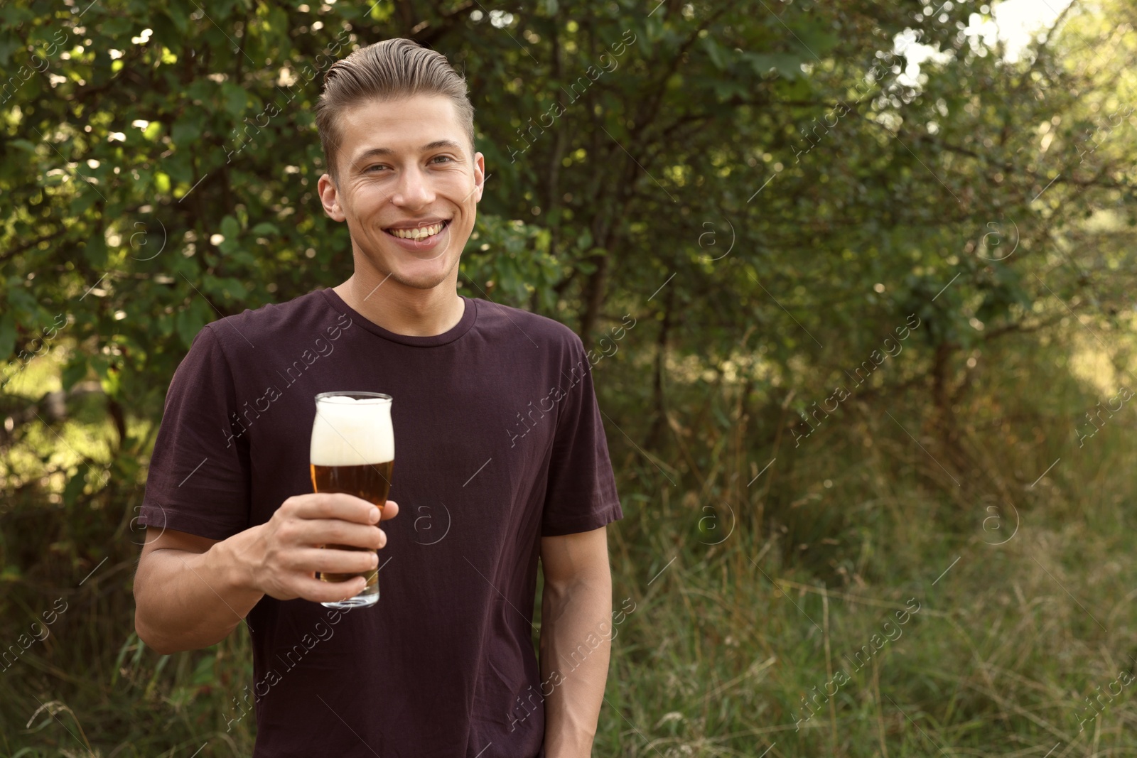 Photo of Young man with glass of beer outdoors
