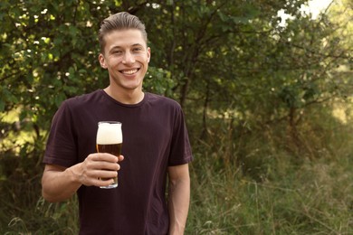 Photo of Young man with glass of beer outdoors