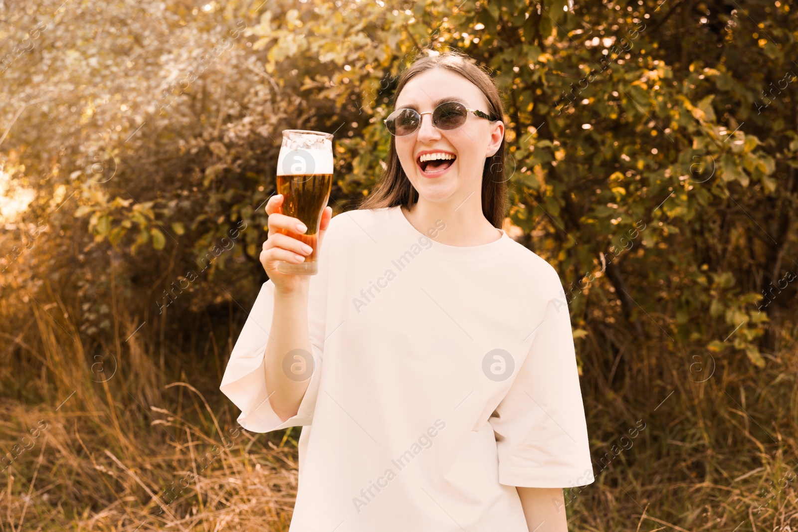 Photo of Young woman with glass of beer outdoors
