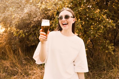 Photo of Young woman with glass of beer outdoors