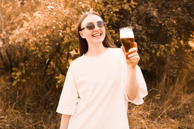 Photo of Young woman with glass of beer outdoors