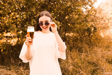 Photo of Young woman with glass of beer outdoors