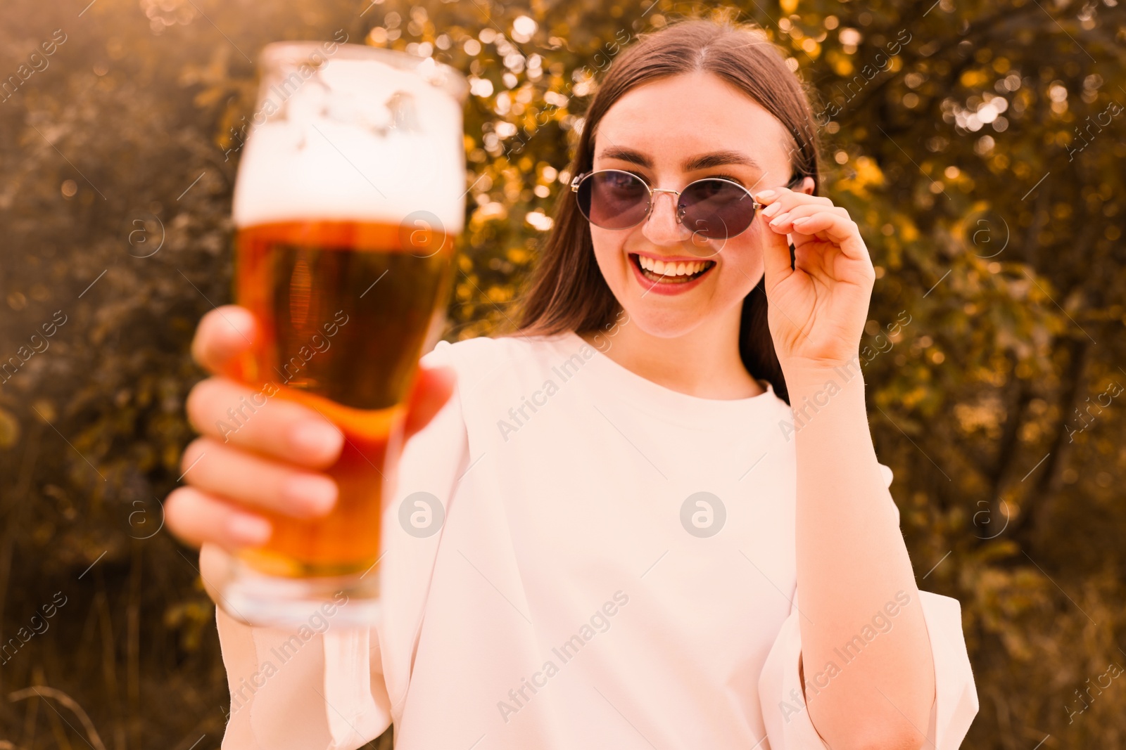 Photo of Young woman with glass of beer outdoors