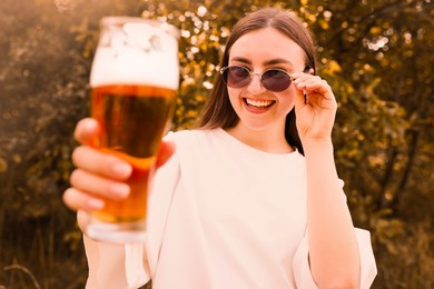 Photo of Young woman with glass of beer outdoors