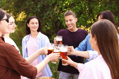 Photo of Group of happy friends clinking glasses of beer outdoors