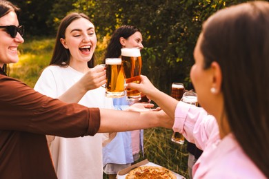 Photo of Group of happy friends clinking glasses of beer outdoors