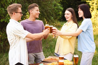 Photo of Group of happy friends clinking glasses of beer outdoors