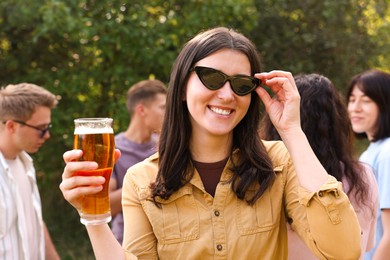 Photo of Group of happy friends having fun and drinking beer outdoors, selective focus