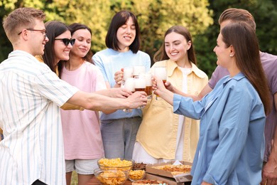 Photo of Group of happy friends clinking glasses of beer outdoors