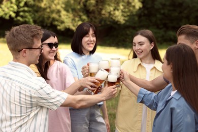 Photo of Group of happy friends clinking glasses of beer outdoors