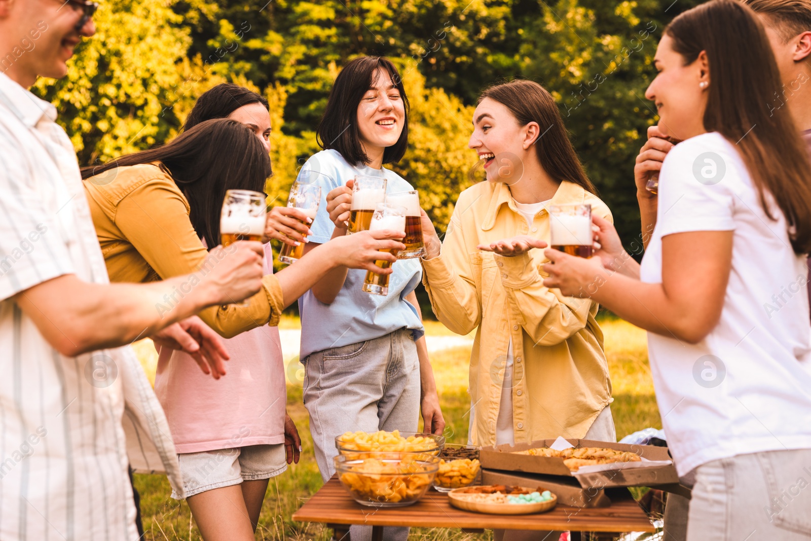 Photo of Group of happy friends having fun and drinking beer outdoors