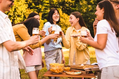 Photo of Group of happy friends having fun and drinking beer outdoors