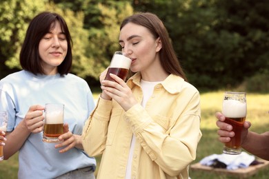 Photo of Group of happy friends having fun and drinking beer outdoors