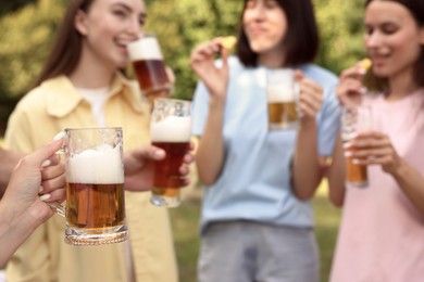 Photo of Group of happy friends having fun and drinking beer outdoors, selective focus