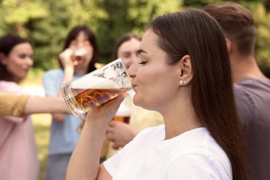 Photo of Group of happy friends having fun and drinking beer outdoors, selective focus