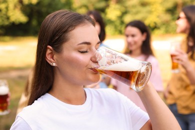 Photo of Group of happy friends having fun and drinking beer outdoors, selective focus
