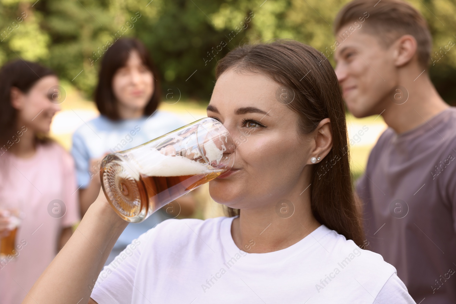Photo of Group of happy friends having fun and drinking beer outdoors, selective focus