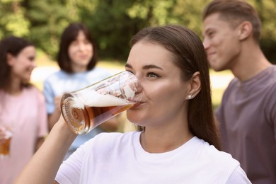 Photo of Group of happy friends having fun and drinking beer outdoors, selective focus