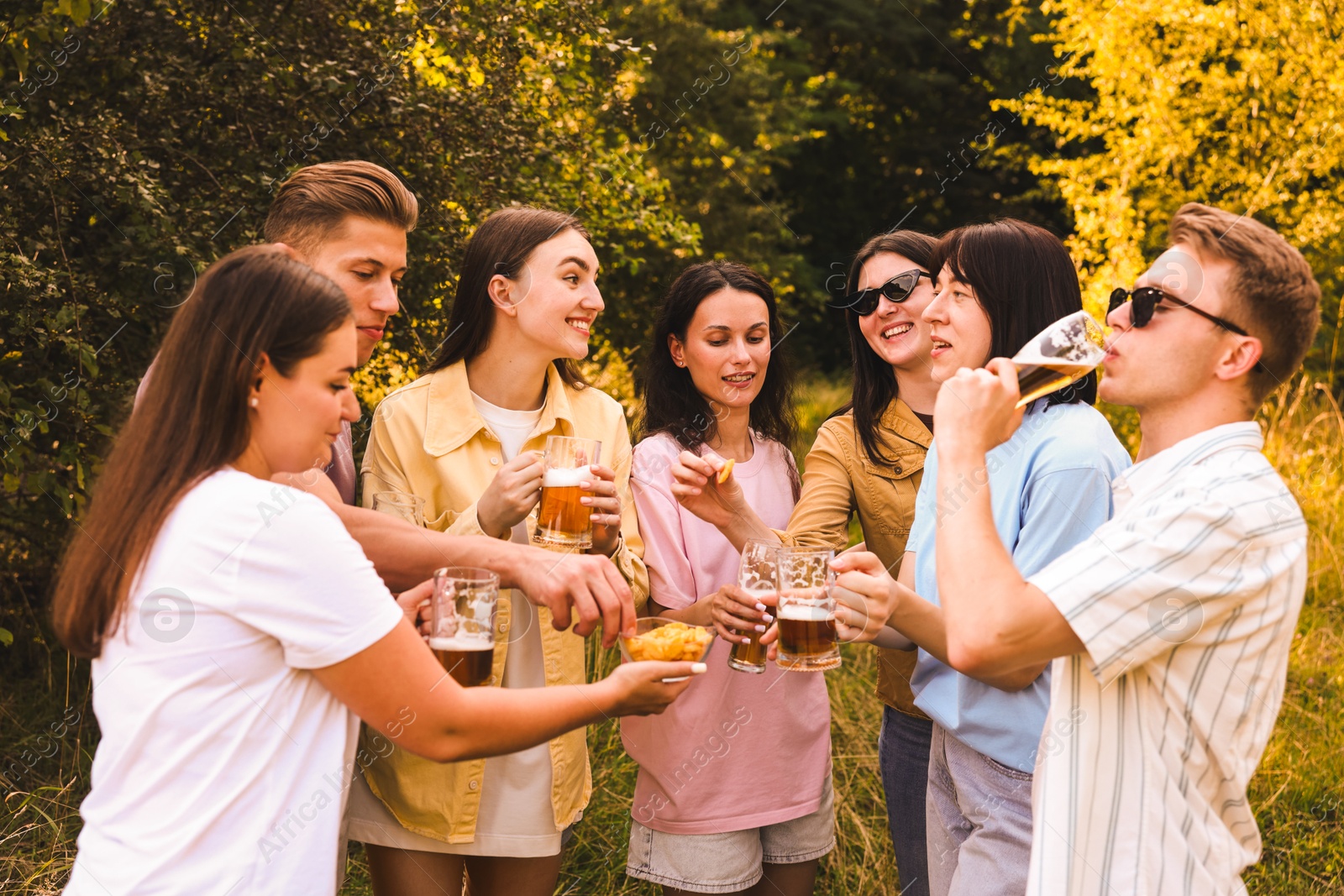 Photo of Group of happy friends having fun and drinking beer outdoors