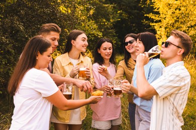 Photo of Group of happy friends having fun and drinking beer outdoors