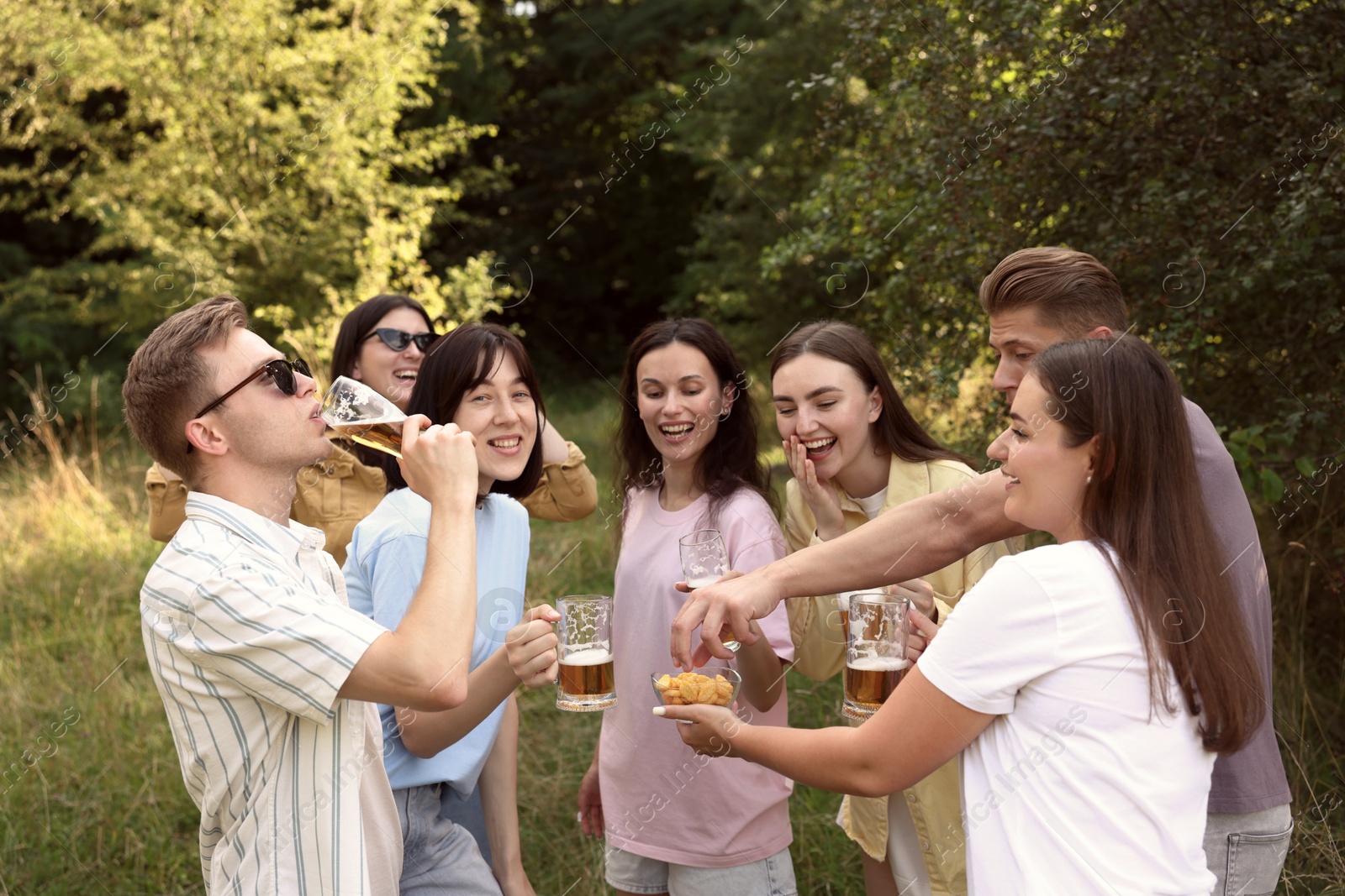Photo of Group of happy friends having fun and drinking beer outdoors