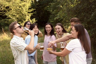 Photo of Group of happy friends having fun and drinking beer outdoors