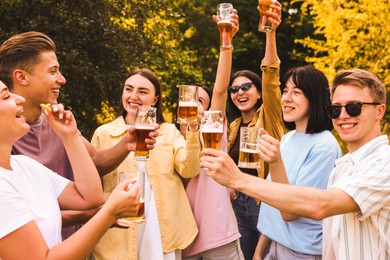 Photo of Group of happy friends having fun and drinking beer outdoors
