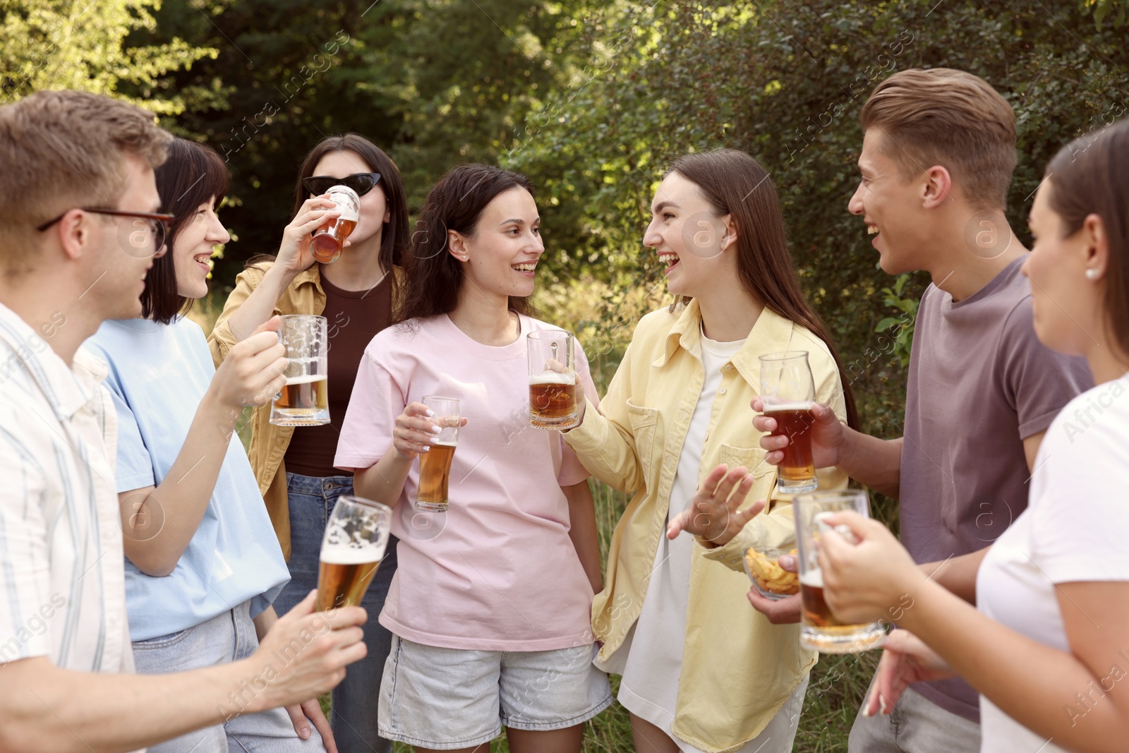Photo of Group of happy friends having fun and drinking beer outdoors