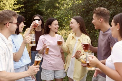 Photo of Group of happy friends having fun and drinking beer outdoors