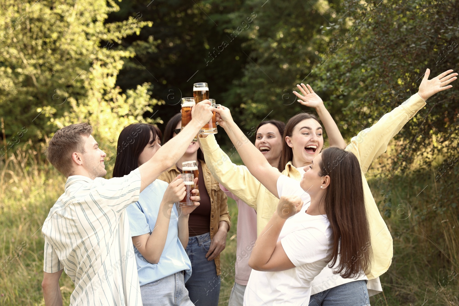 Group of happy friends clinking glasses of beer outdoors Photo of Group of happy friends clinking glasses of beer outdoors