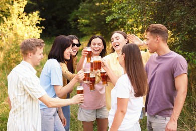 Photo of Group of happy friends clinking glasses of beer outdoors