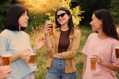 Photo of Group of happy friends having fun and drinking beer outdoors