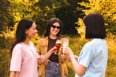 Photo of Group of happy friends clinking glasses of beer outdoors