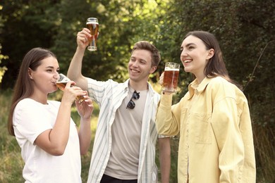Photo of Group of happy friends having fun and drinking beer outdoors