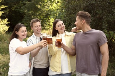 Photo of Group of happy friends clinking glasses of beer outdoors