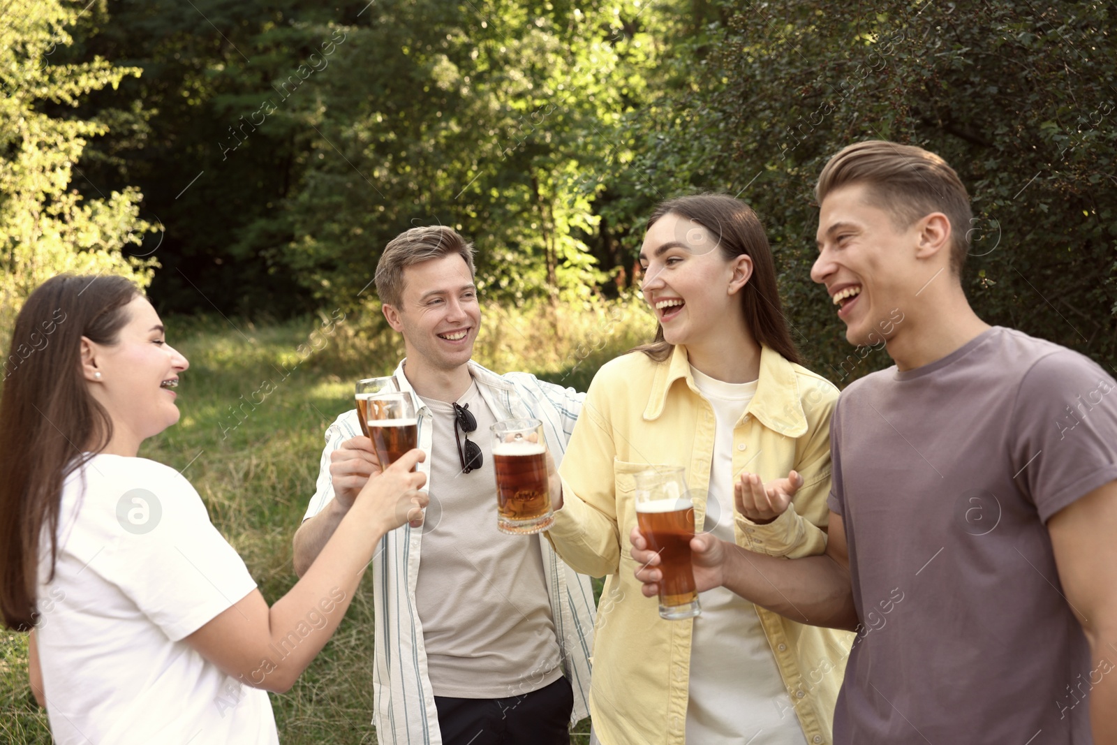 Photo of Group of happy friends having fun and drinking beer outdoors