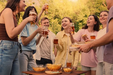 Photo of Group of happy friends having fun and drinking beer outdoors