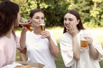 Photo of Group of happy friends having fun and drinking beer outdoors