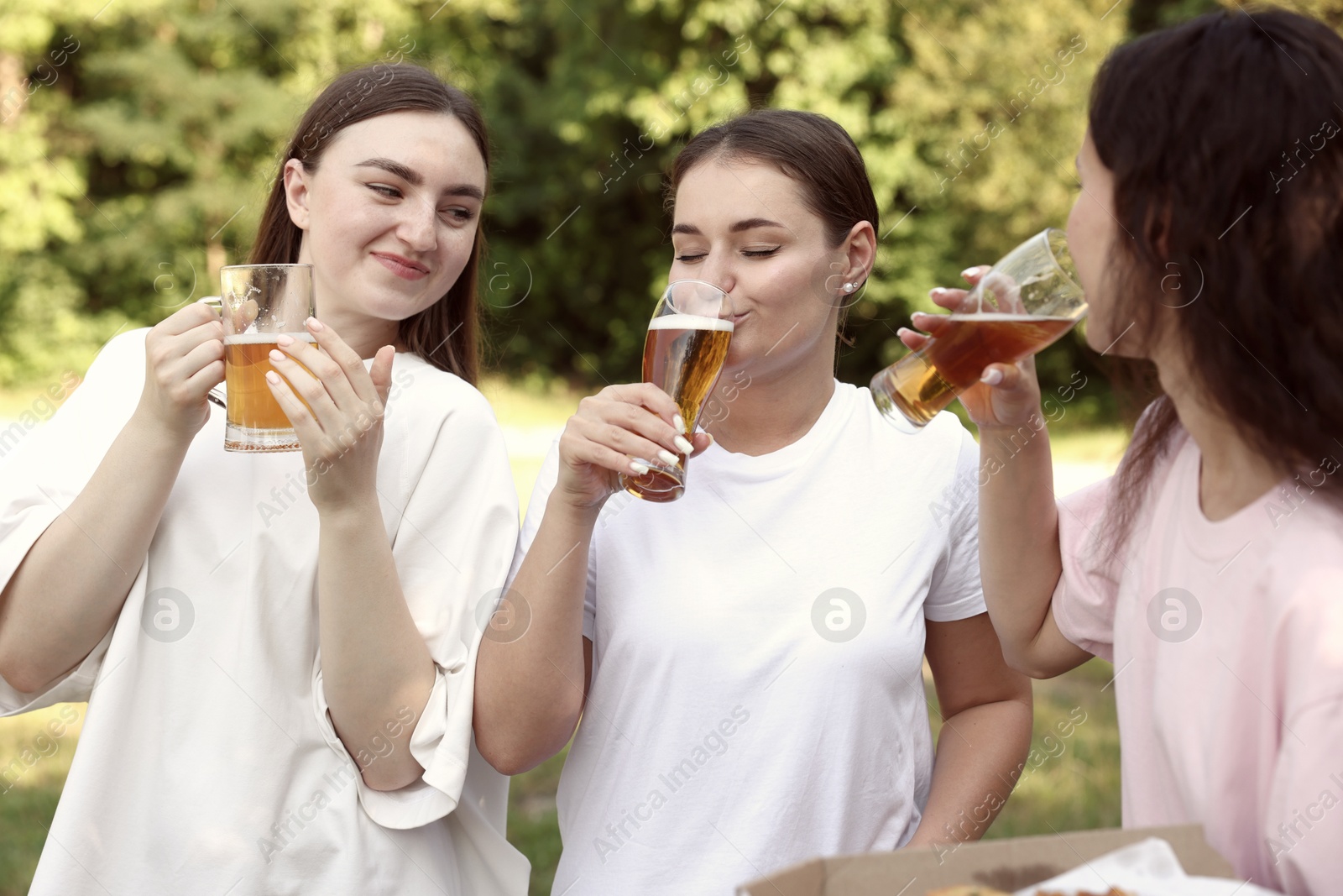 Group of happy friends having fun and drinking beer outdoors Photo of Group of happy friends having fun and drinking beer outdoors