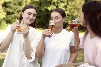 Photo of Group of happy friends having fun and drinking beer outdoors