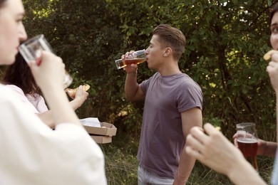 Photo of Group of happy friends having fun and drinking beer outdoors