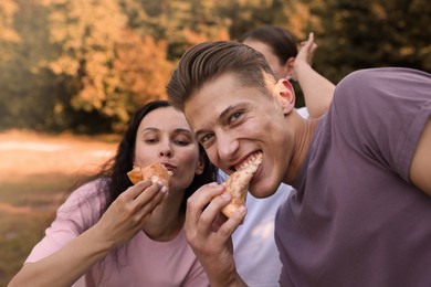 Photo of Group of people eating tasty pizza outdoors