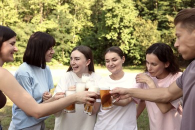 Photo of Group of happy friends clinking glasses of beer outdoors