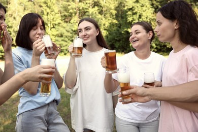 Photo of Group of happy friends having fun and drinking beer outdoors