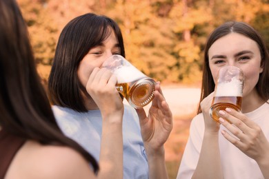 Photo of Group of happy friends having fun and drinking beer outdoors