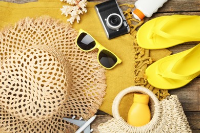 Photo of Beach accessories, camera and toy plane on wooden background, flat lay. Time for summer vacation