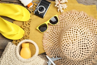 Photo of Beach accessories, camera and toy plane on wooden background, flat lay. Time for summer vacation