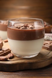 Photo of Delicious panna cotta with chocolate and cocoa beans on wooden table, closeup
