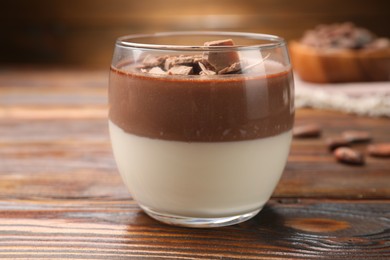 Photo of Delicious panna cotta with chocolate on wooden table, closeup